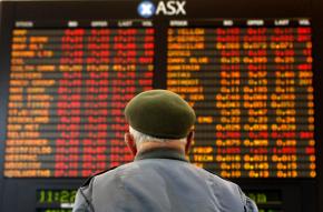 A man looks up at stock prices on the Australian stock market