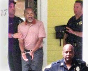A photo, taken by a neighbor, of Black scholar Henry Louis Gates led out of his own home in handcuffs