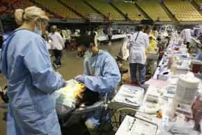 Volunteer dentists provide care on the floor of the Great Western Forum in Los Angeles