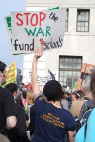 A UESF member rallies for funding for schools, not war