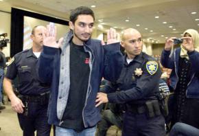 A UC Irvine student is escorted from a lecture hall after a protest against Israeli Ambassador Michael Oren