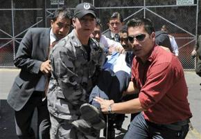 Ecuador's President Rafael Correa is taken away after being overcome by tear gas