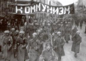 Members of the Red Guard march under the banner of "Communism" following the 1917 Russian Revolution