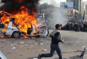 A car burns in the middle of the street as Libyans continue their mass protests against dictatorship
