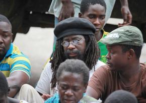 Munyaradzi Gwisai (center with glasses) sits with fellow activists outside a court house in Harare