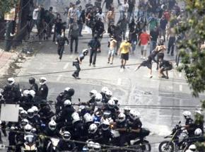 Protesters fend off a group of riot police advancing down the streets of Athens