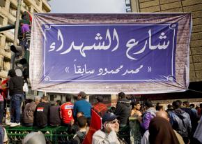 Protesters hang a banner at the entrance to Mohammad Mahmoud Street renaming it "Martyrs Street"