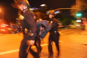 Police arrest an activist penned into the Occupy LA camp