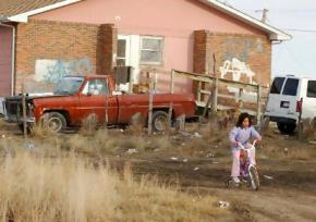 A girl plays outside her home on an American Indian reservation