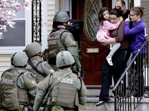Heavily armed police search a family's home in locked-down Boston