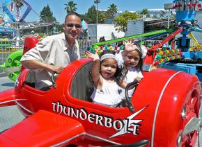 Jose de la Trinidad at an amusement park with his daughters