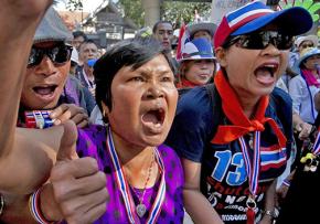 Anti-government protesters demonstrate outside police headquarters in Bangkok