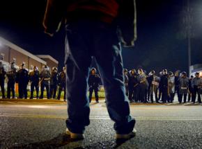 A protester faces down a line of riot police in Ferguson