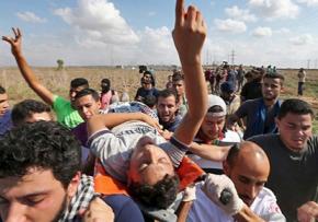 Protesters carry a wounded man injured by Israeli military attacks