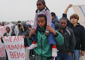 Refugees and solidarity activists march in the northern French city of Calais