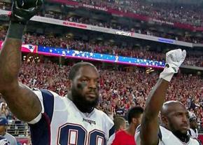 Martellus Bennett and Devin McCourty of the New England Patriots raise their fists during the National Anthem