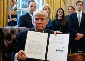 Trump displays his signature on an executive order in the Oval Office