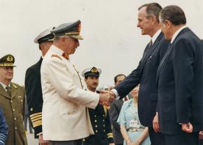Chilean dictator Augusto Pinochet exchanges greetings with then President George H.W. Bush