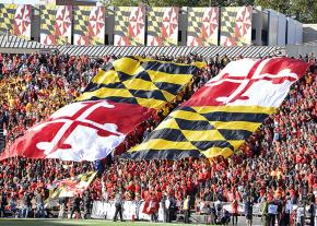 Giant Maryland flags in the stands at a UMD football game
