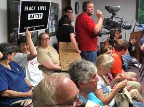 Protesters attend a city council meeting in Nelsonville, Ohio, to demand the firing of a racist police officer